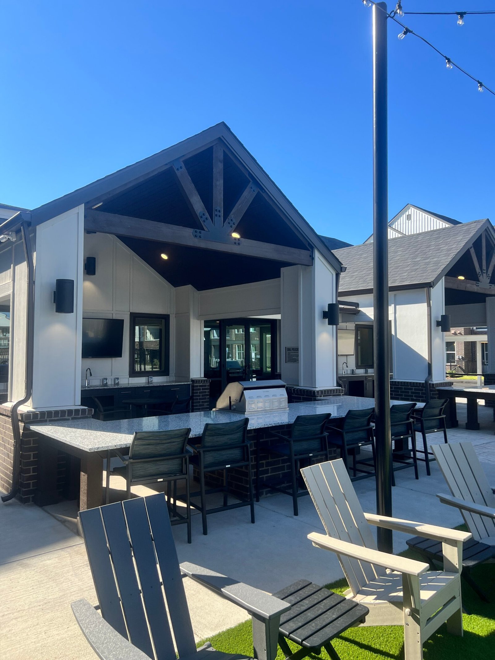 Outdoor grill courtyard amenity space with seating at a Florida apartment community
