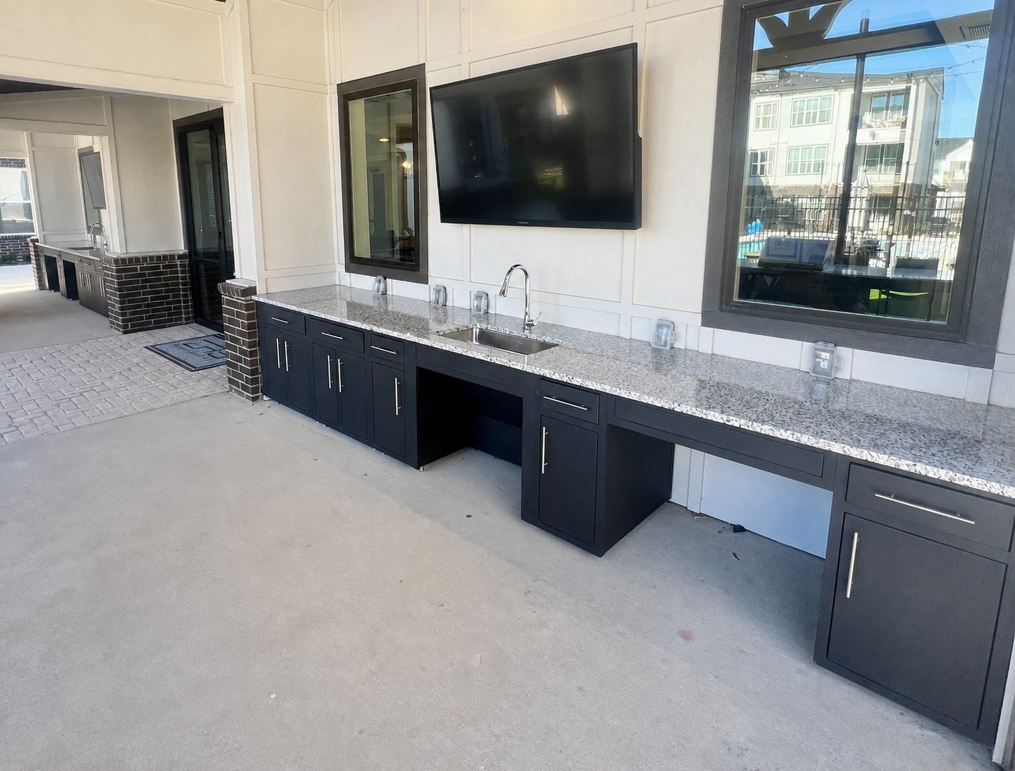 ADA compliant outdoor kitchen with modular cabinetry and two lowered open counter sections at Aspire Apartments in Sherman, TX