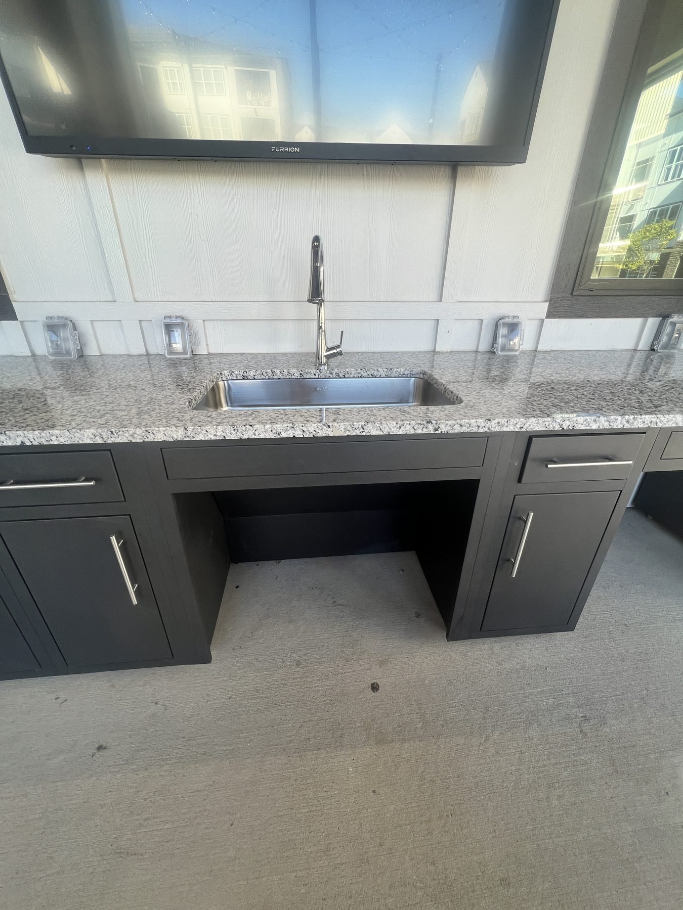 ADA compliant outdoor kitchen sink with open knee clearance underneath at Aspire Apartments in Sherman, TX
