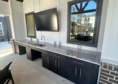 Full run of black modular outdoor kitchen cabinets with ADA sink section at a multi-family community. Project: Majestic ADA Design. Builder: Majestic Outdoor Kitchens